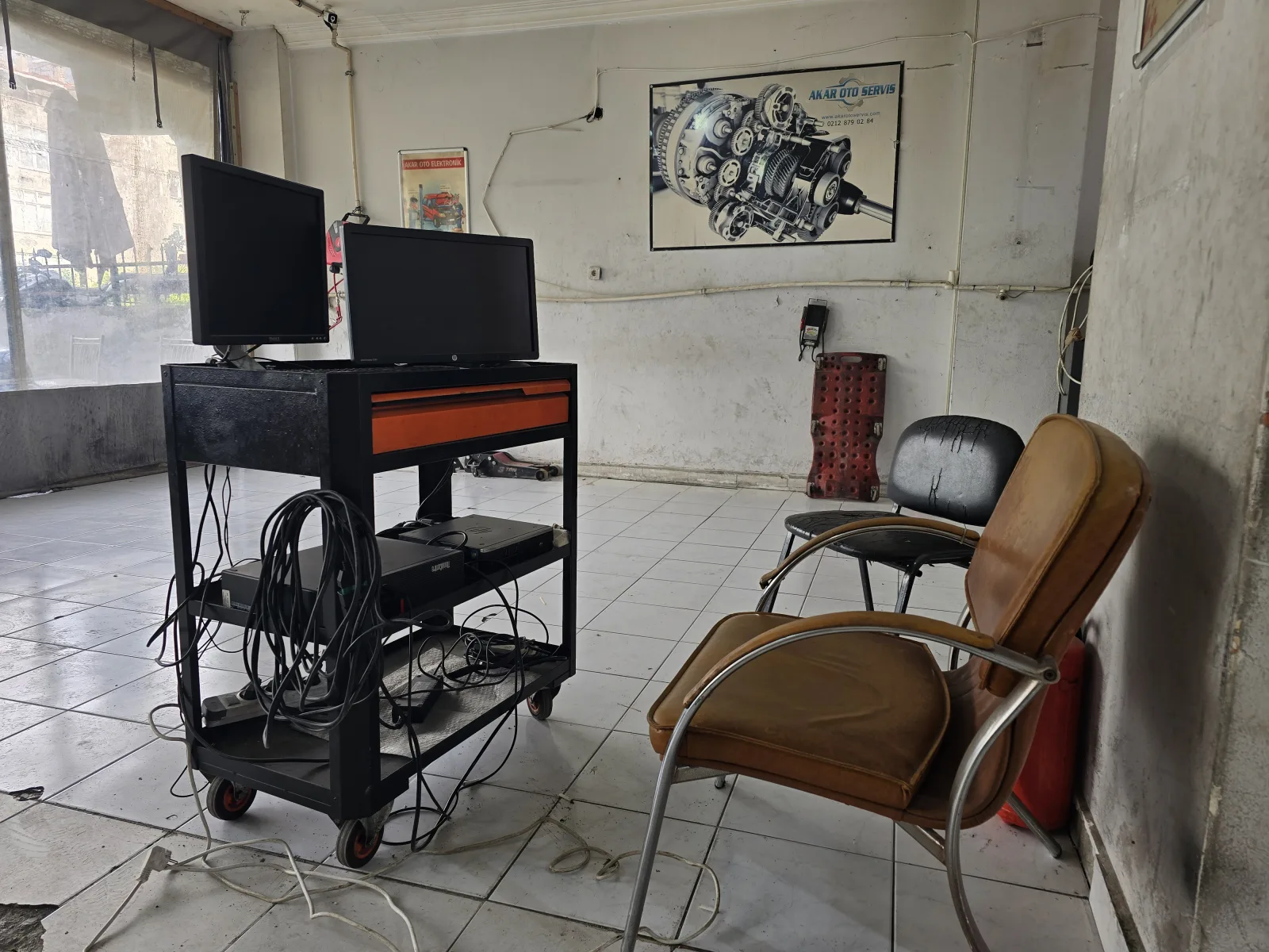 Çift monitörlü teşhis masası ve duvarda otomatik şanzıman kesit şeması