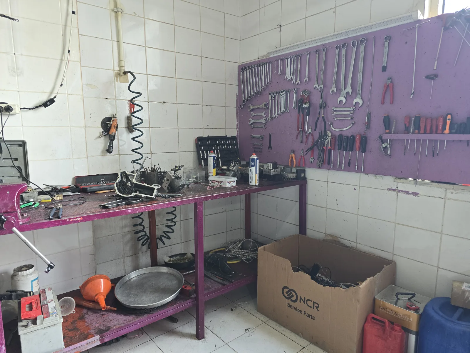 Tezgâhın üstündeki panoya asılmış el aletleri ve ölçüm ekipmanı
