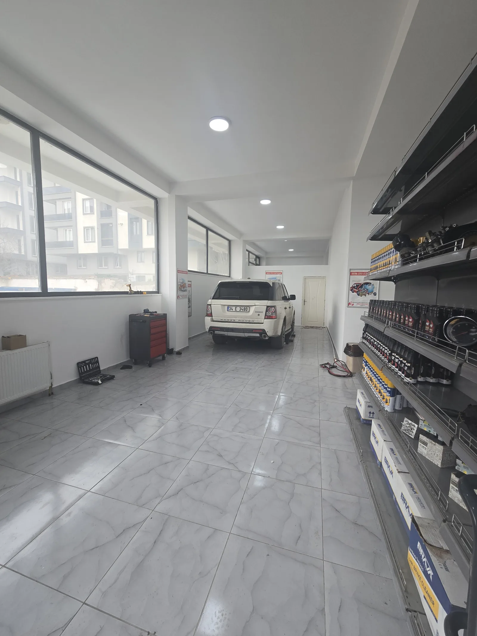 Yeni dükkânın servis koridoru ve tavana yakın uzanan raf hattı