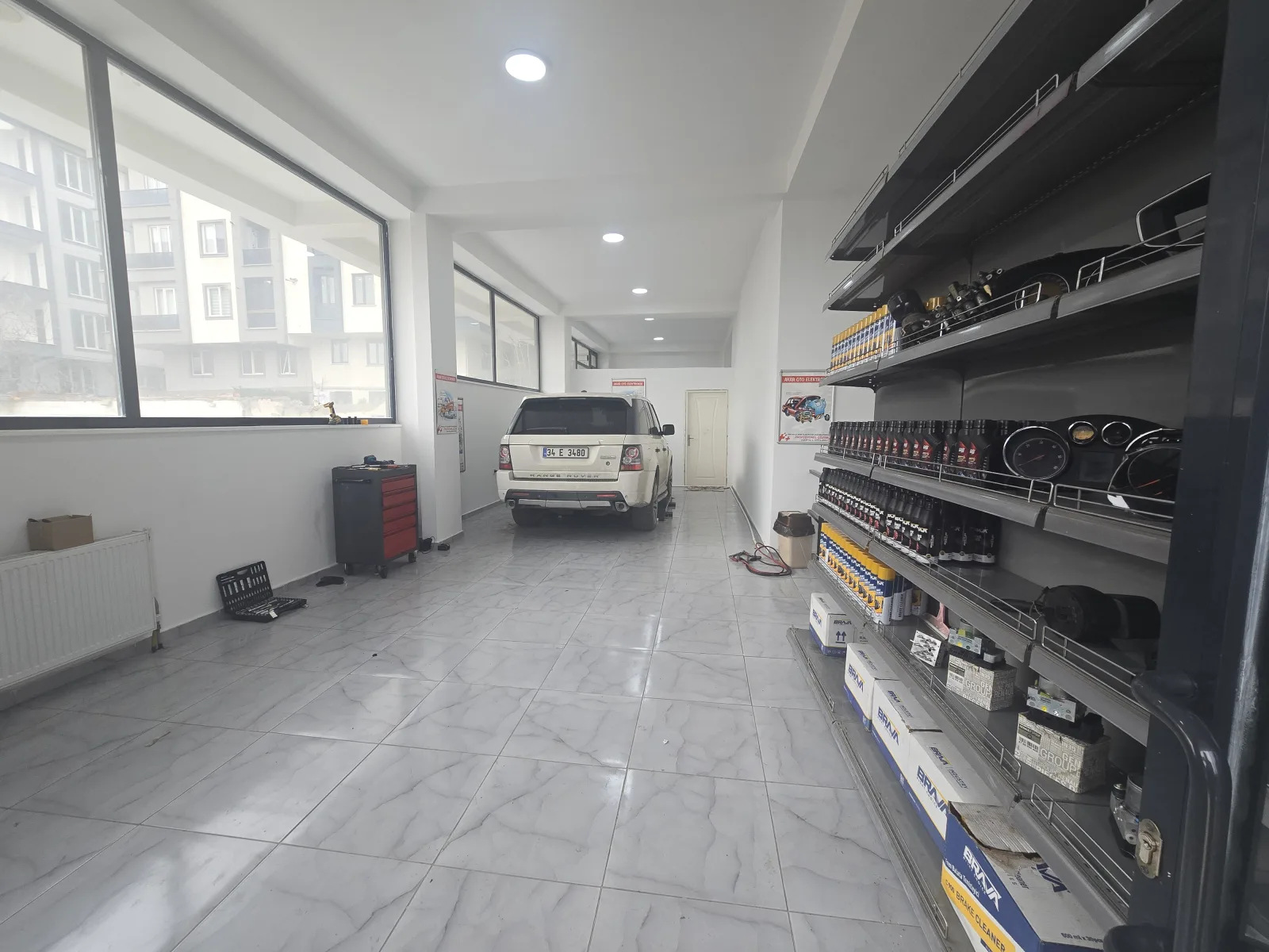 Yeni dükkânın aydınlık iç mekânı; içeride servis için bekleyen bir araç
