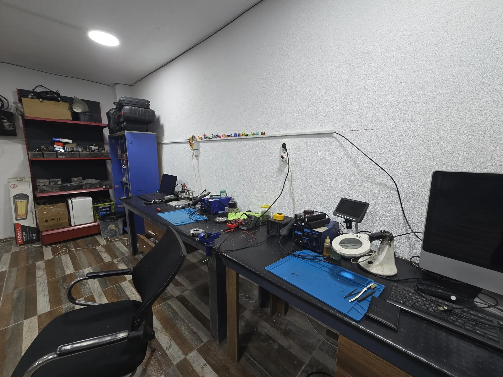 Çalışma tezgâhında ölçüm aletleri, lehim istasyonu ve bilgisayar
